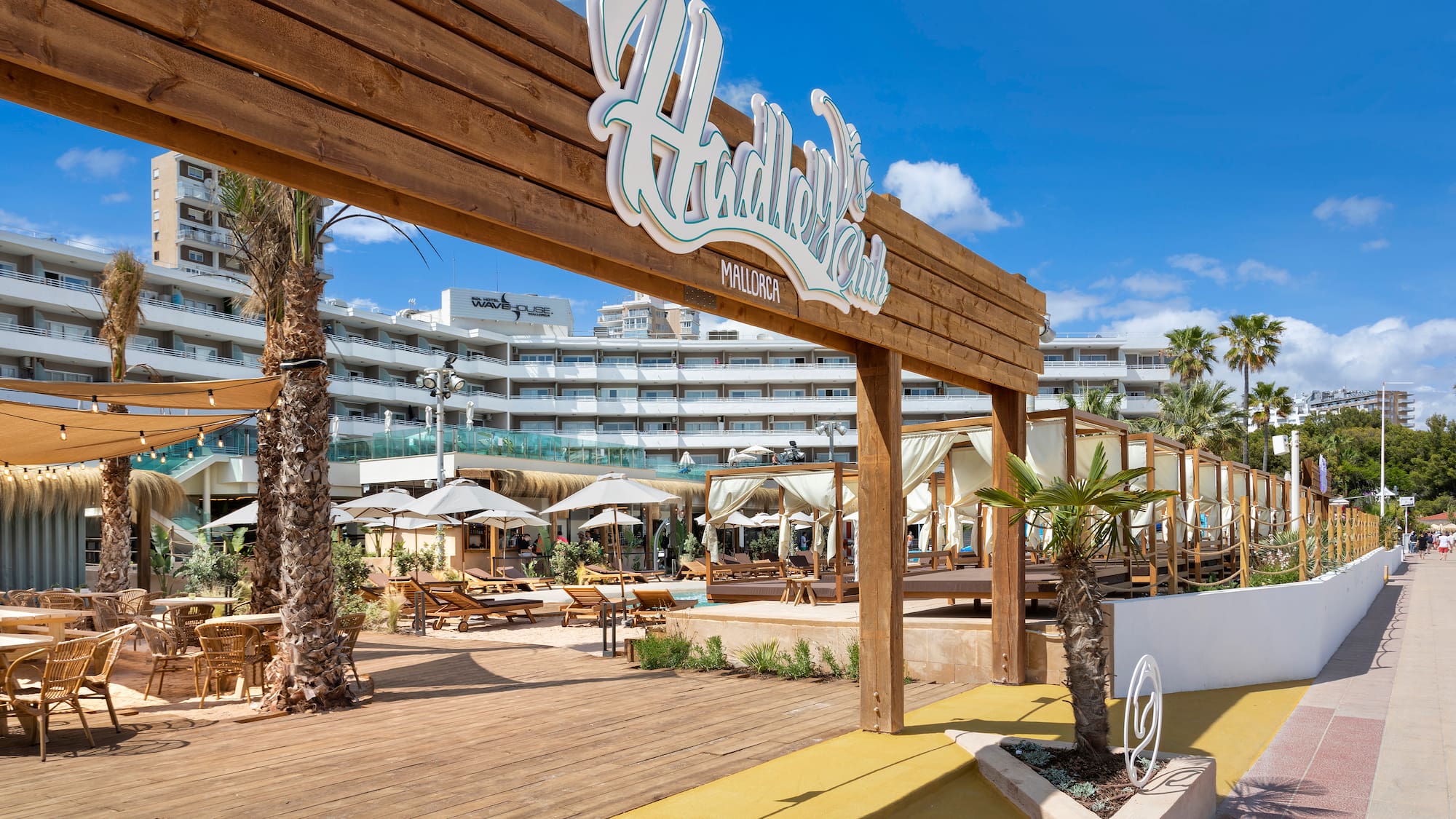 a wooden sign with palm trees and umbrellas