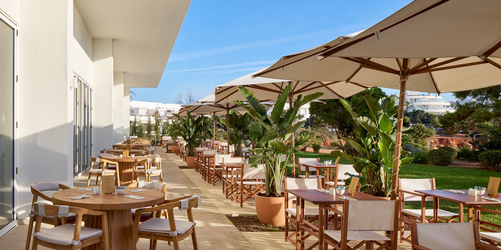 a patio with tables and chairs and umbrellas
