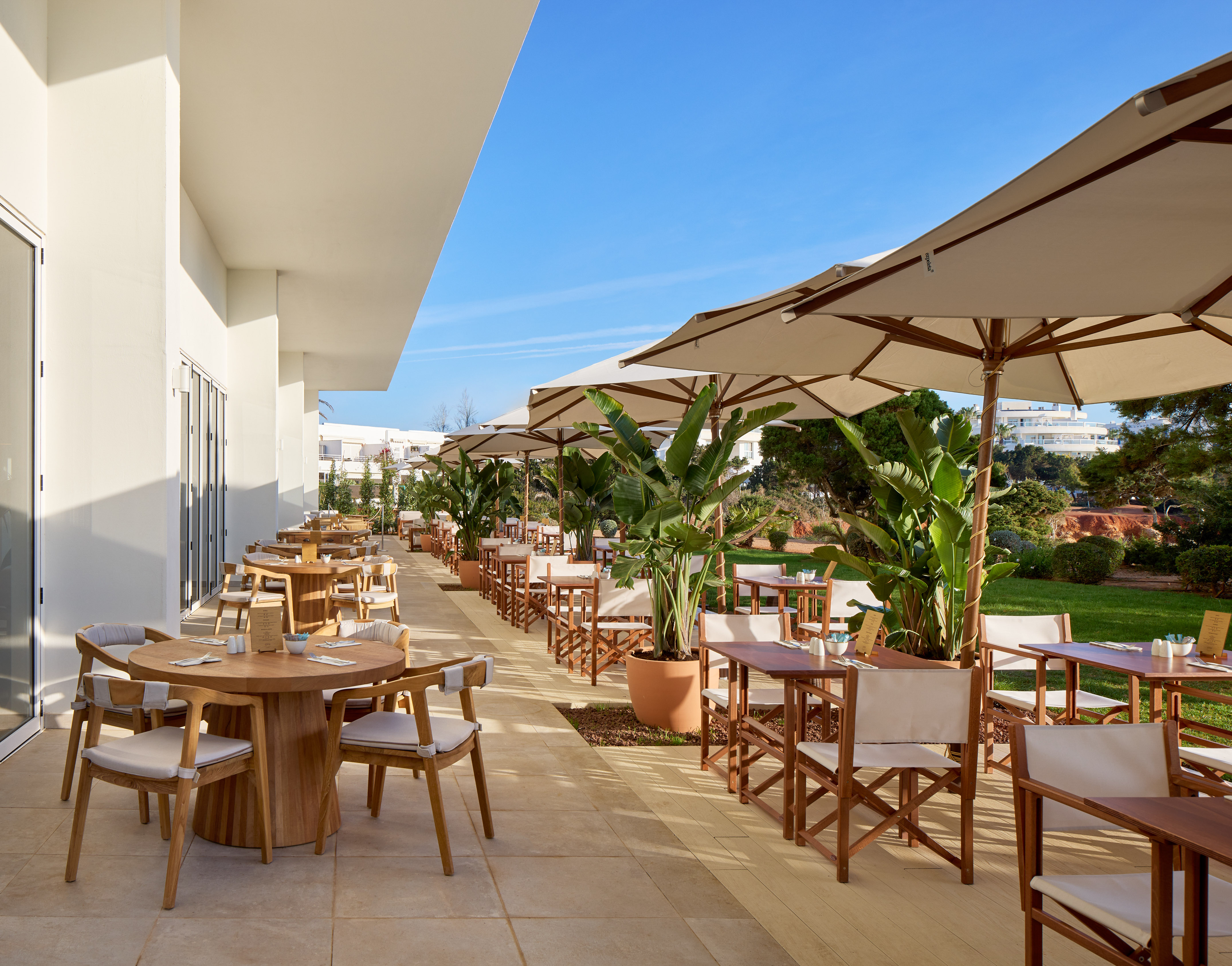 a patio with tables and chairs and umbrellas