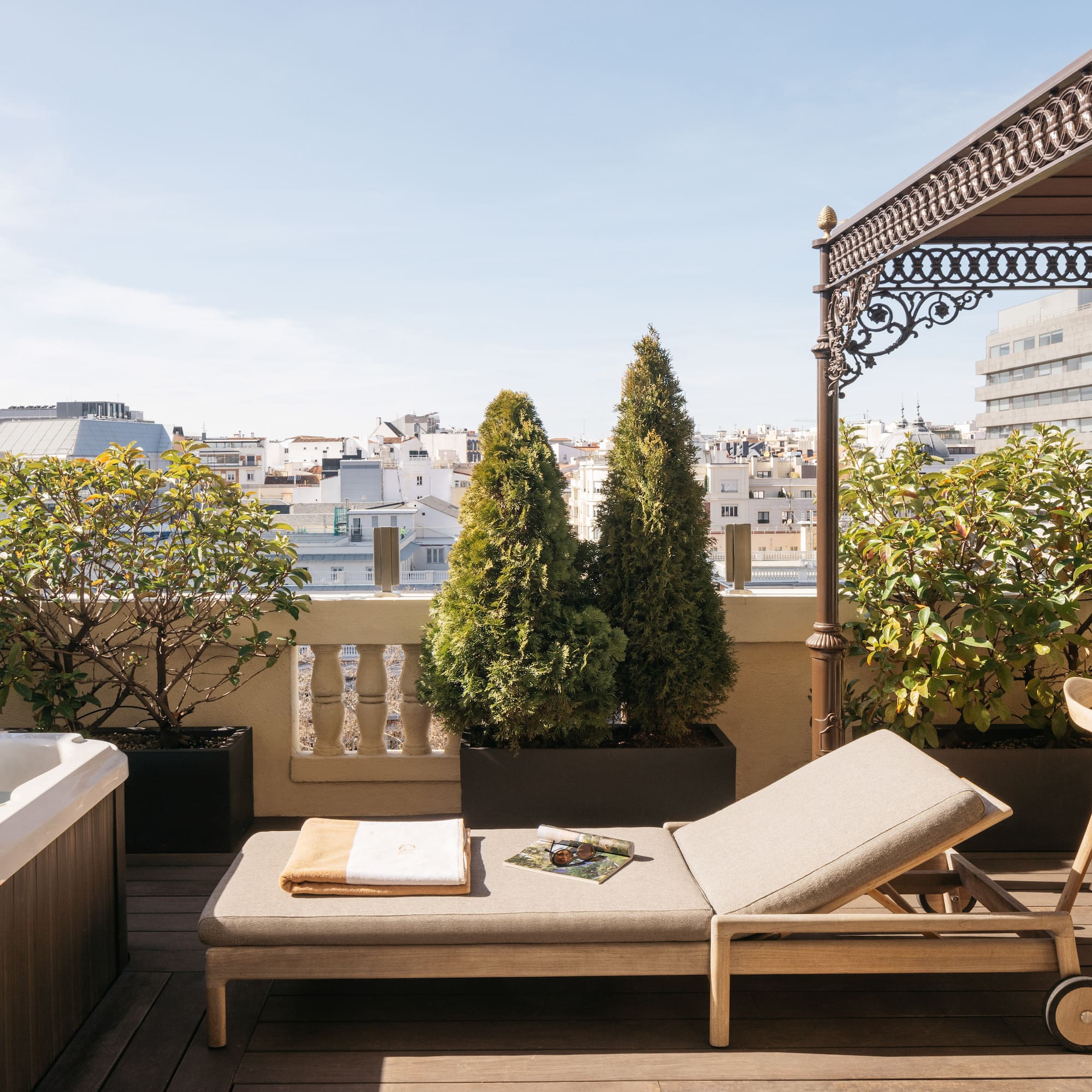 a deck with a hot tub and a lounge chair.