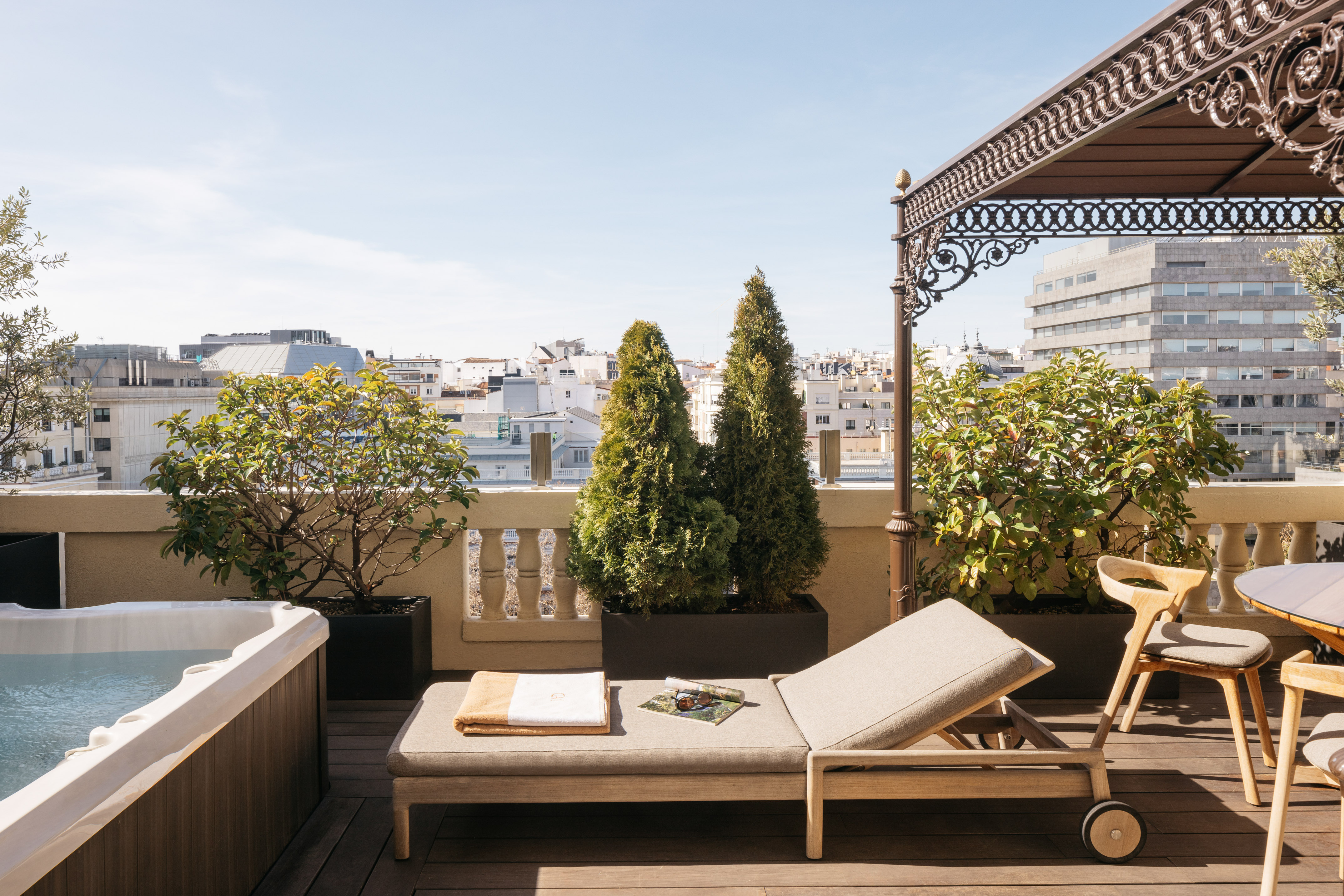 Rooftop terrace with jacuzzi, sun lounger, and city views.