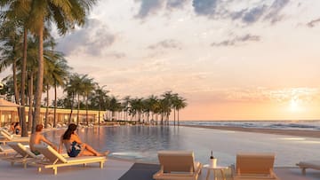 a woman sitting on a lounge chair next to a pool