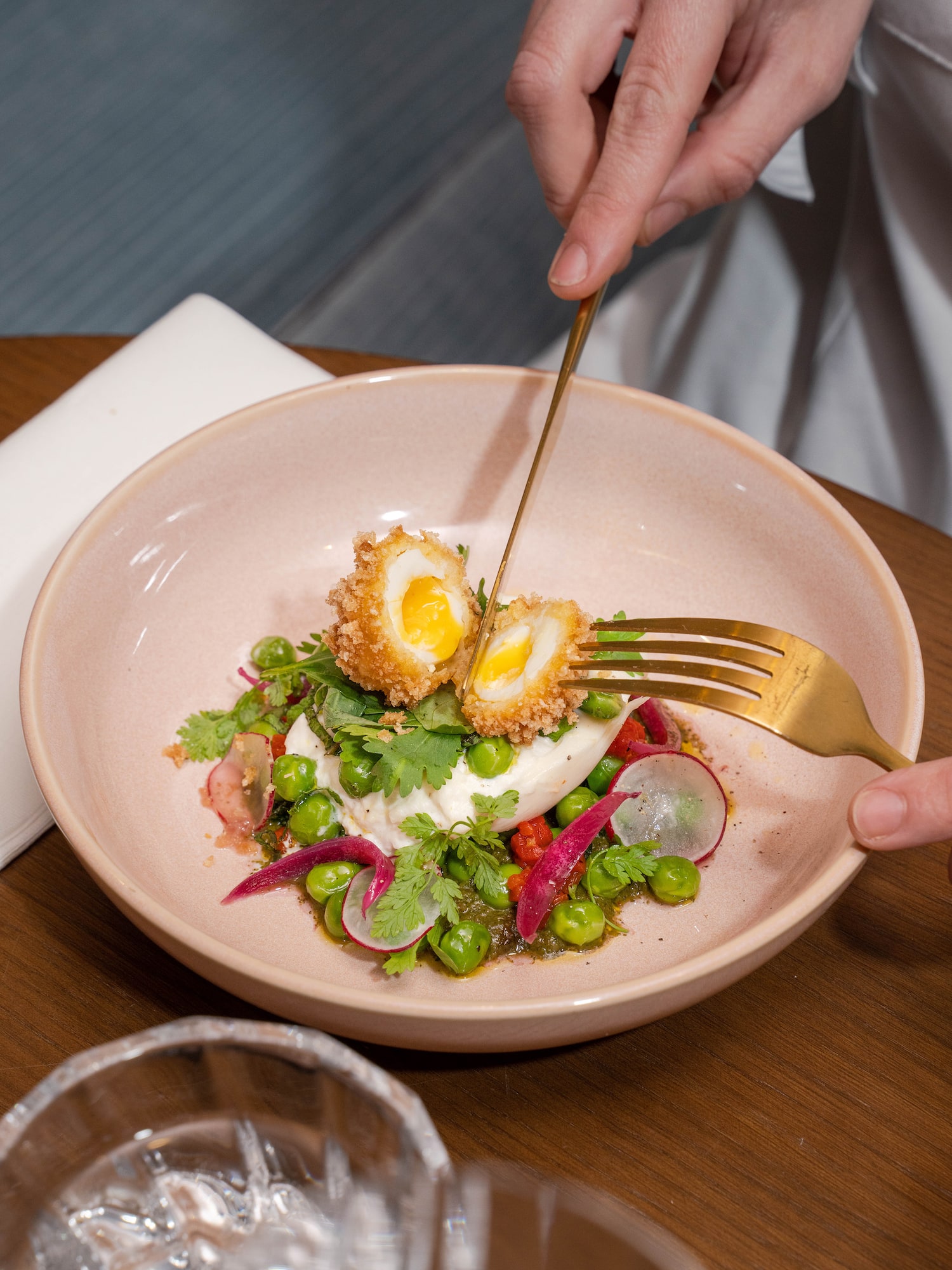 a person holding a fork and eating a salad