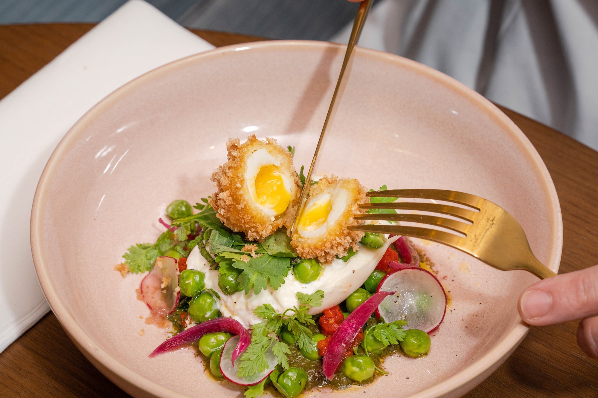 a person holding a fork and eating a salad