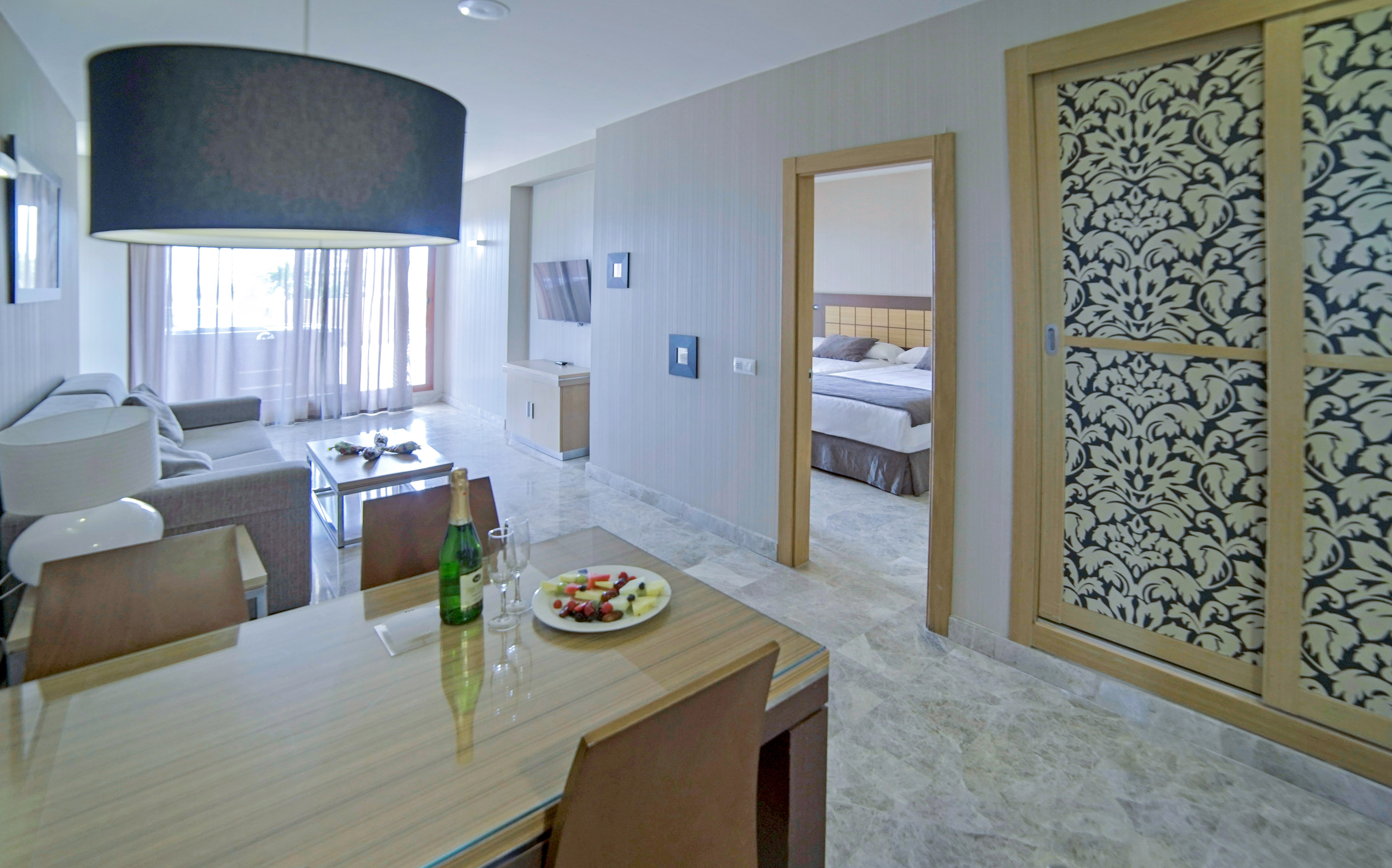 a room with a table and chairs and a bed and a tv