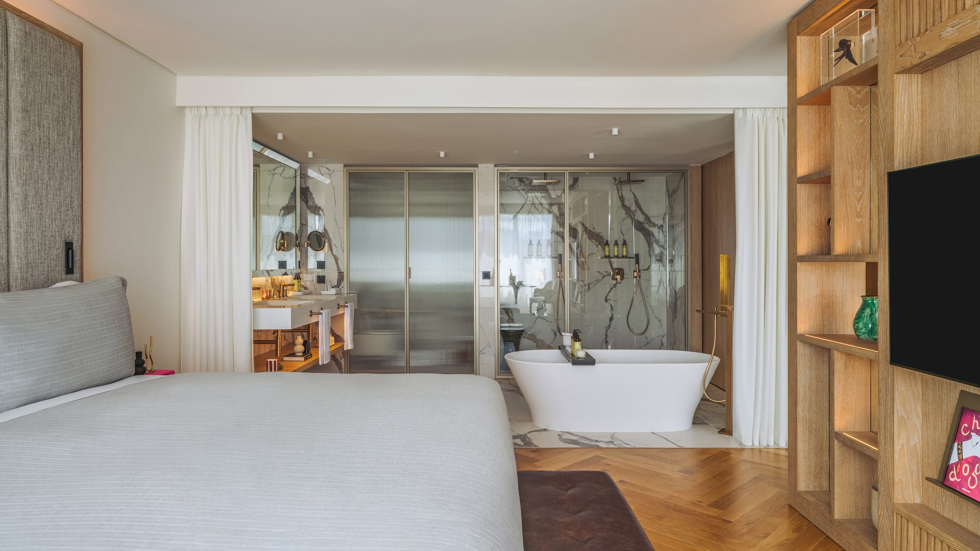 a bedroom with a bathtub and a bookcase
