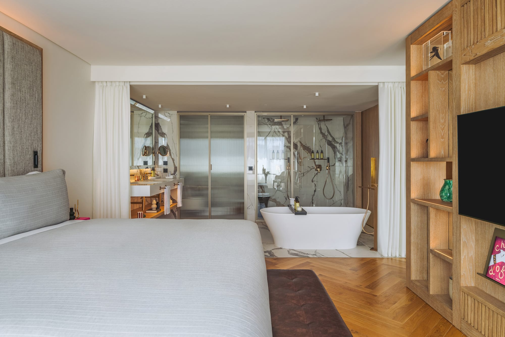 a bedroom with a bathtub and a bookcase