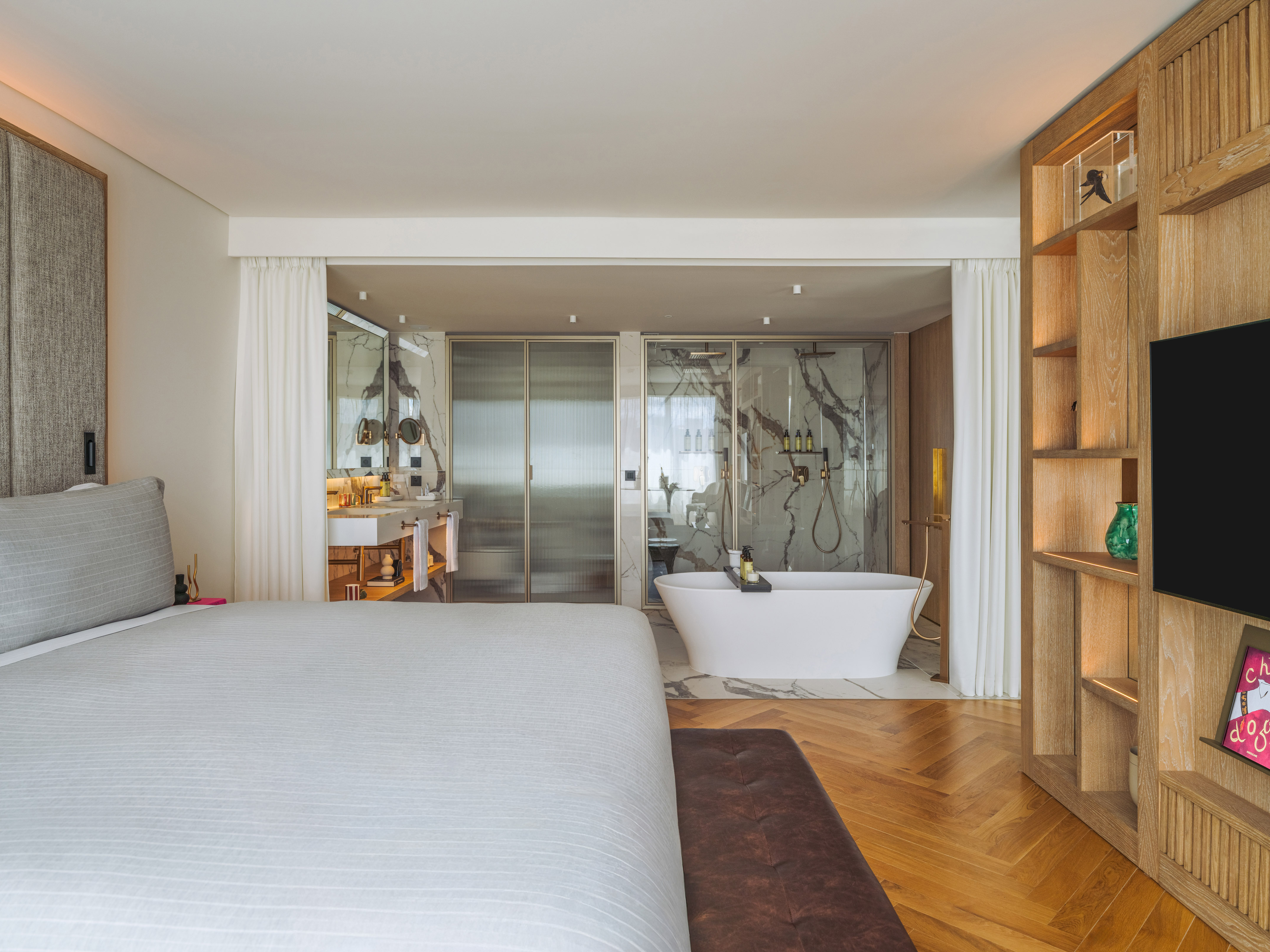a bedroom with a bathtub and a bookcase