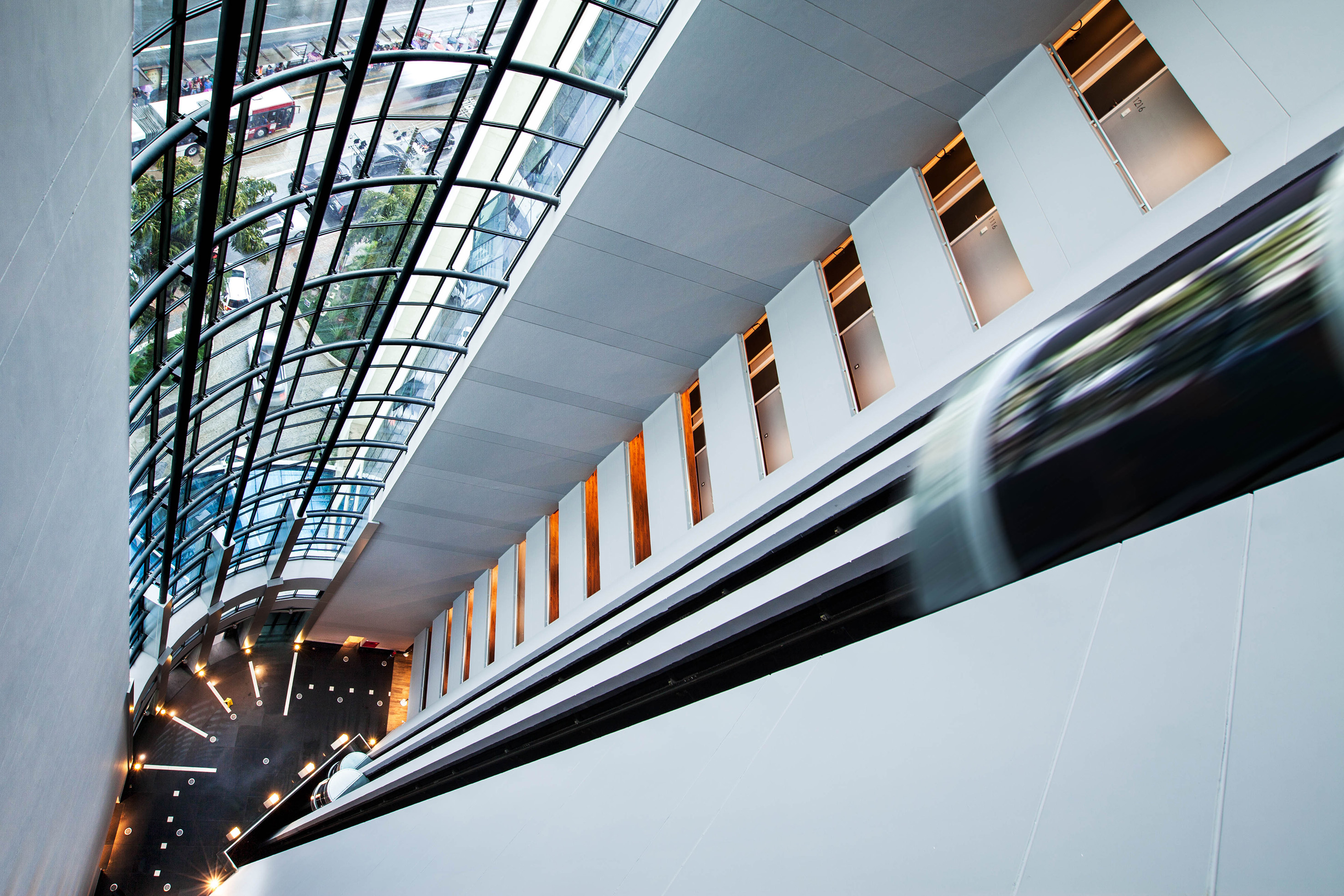 Modern architectural interior, curved glass roof, urban street, moving escalator.