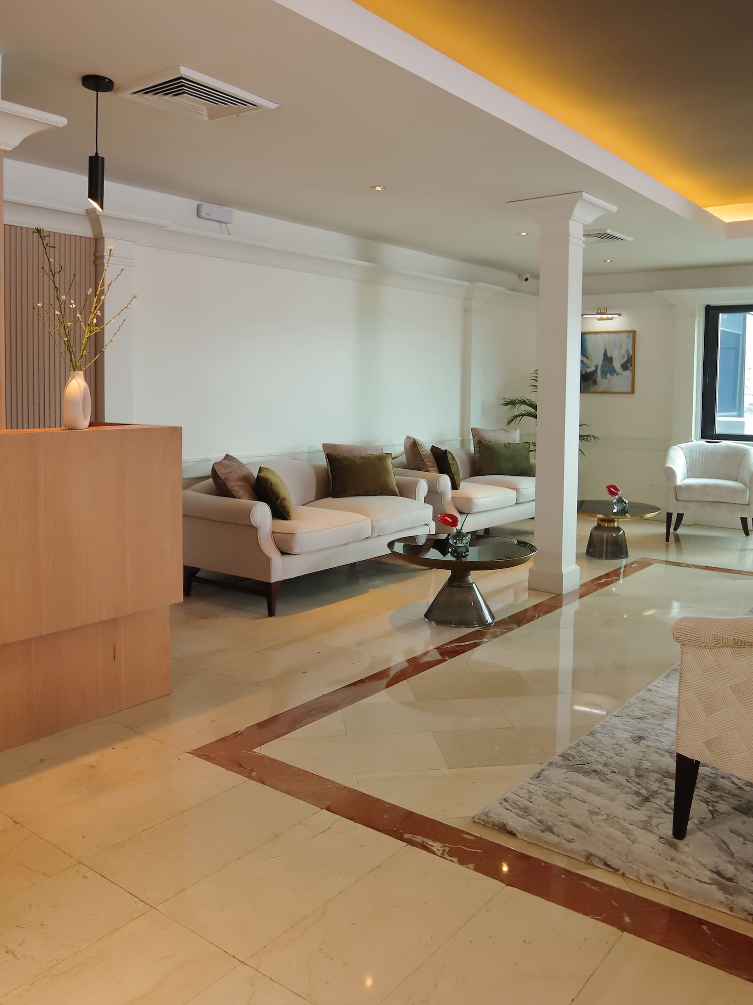 a room with a marble floor and white furniture