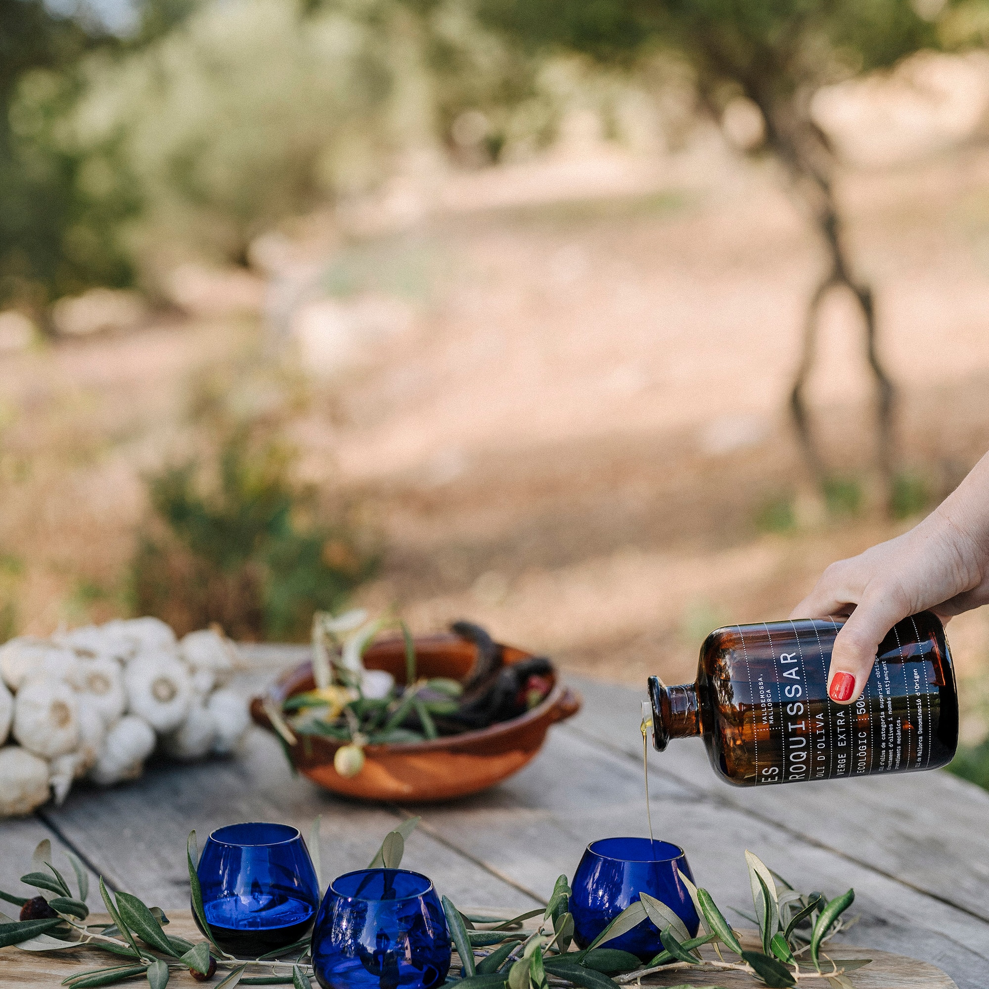 a person pouring a bottle into blue cups