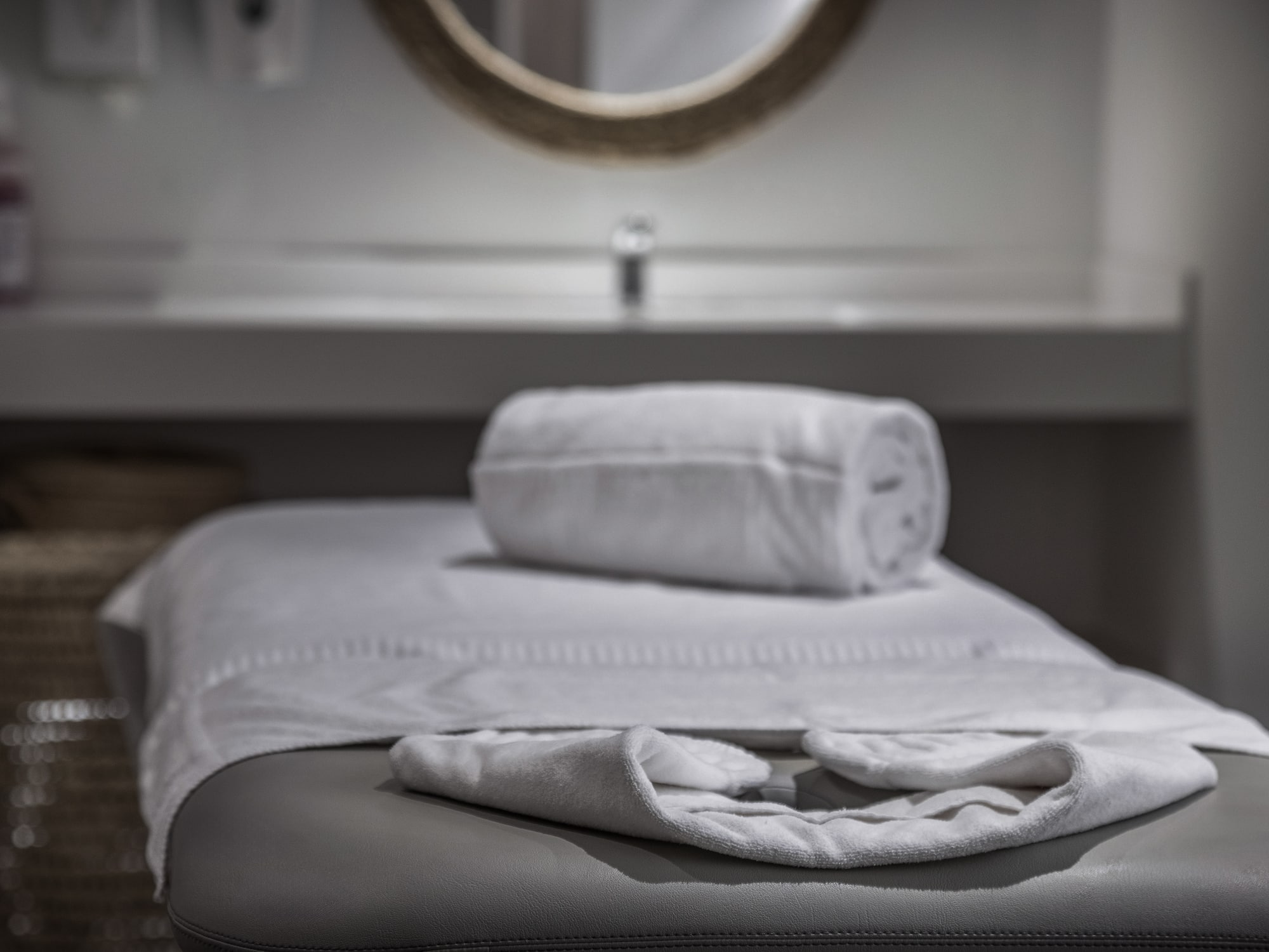 Clean white towels on a spa massage table in a tranquil treatment room.