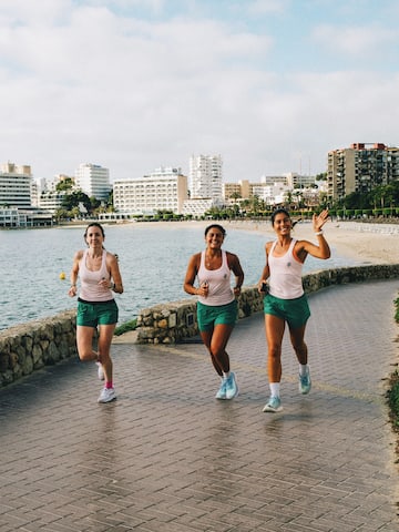 a group of women running on a path near water