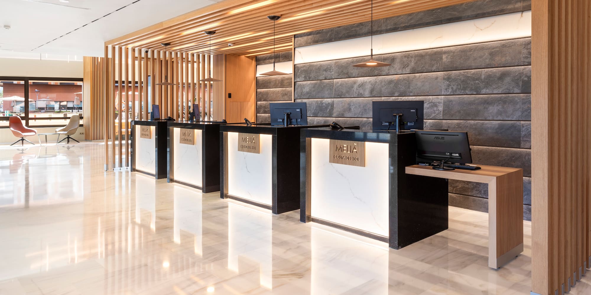 a reception area with computers and a marble floor