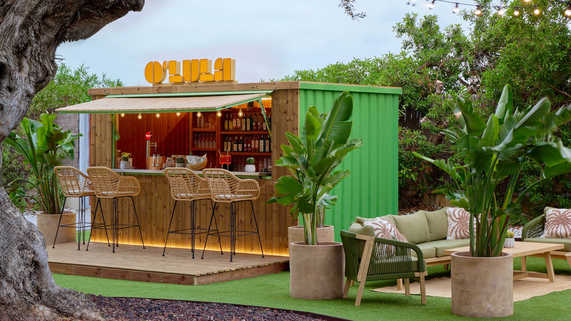 OLULA garden bar, green container design, rattan stools, modern lounge area.