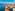 Lido di Venezia cityscape: red-roofed buildings, historic dome, blue lagoon.