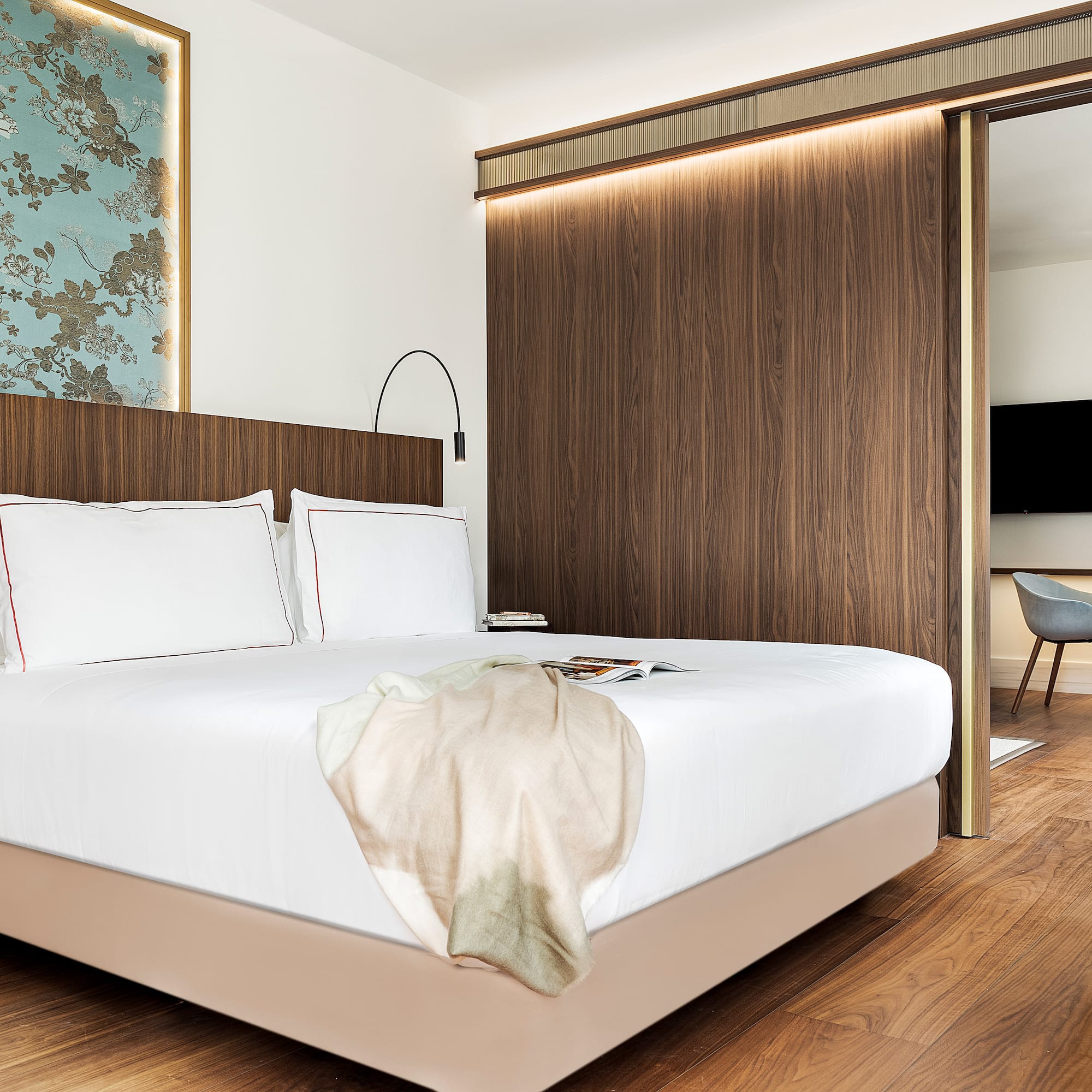 a bed with a wood paneled wall and a mirror