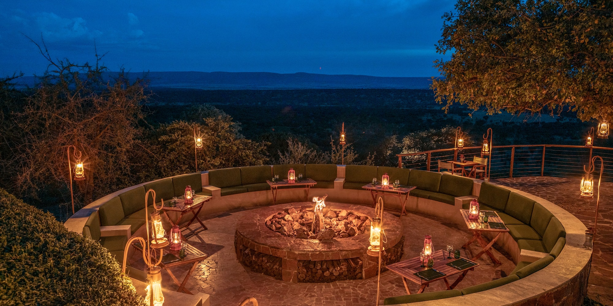 a fire pit with candles and tables on a stone patio
