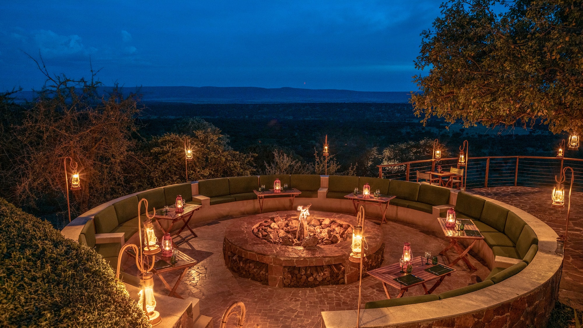 a fire pit with candles and tables on a stone patio