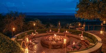 a fire pit with candles and tables on a stone patio