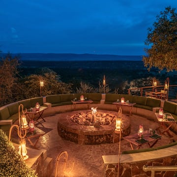 a fire pit with candles and tables on a stone patio