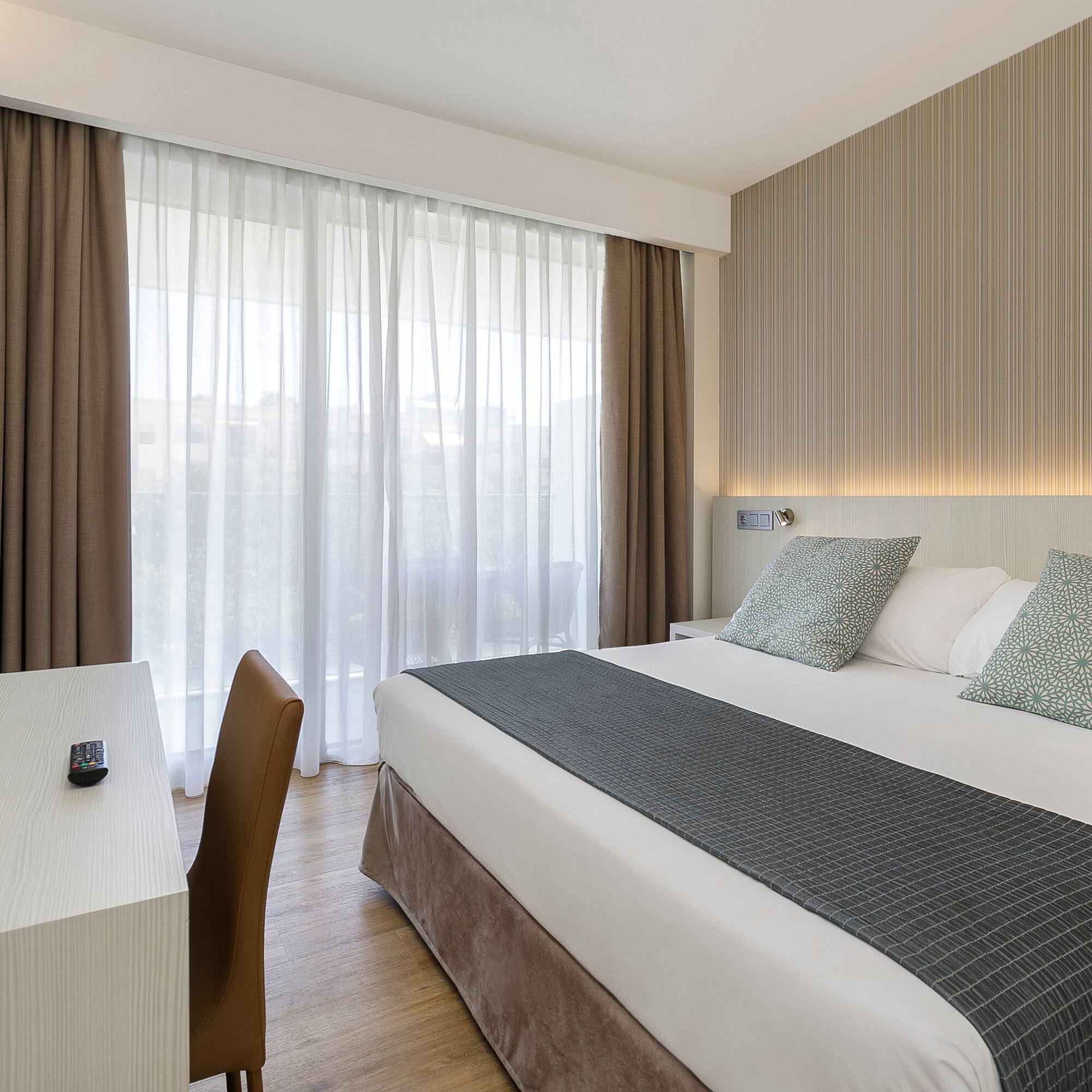 a bed with a desk and chair in a hotel room