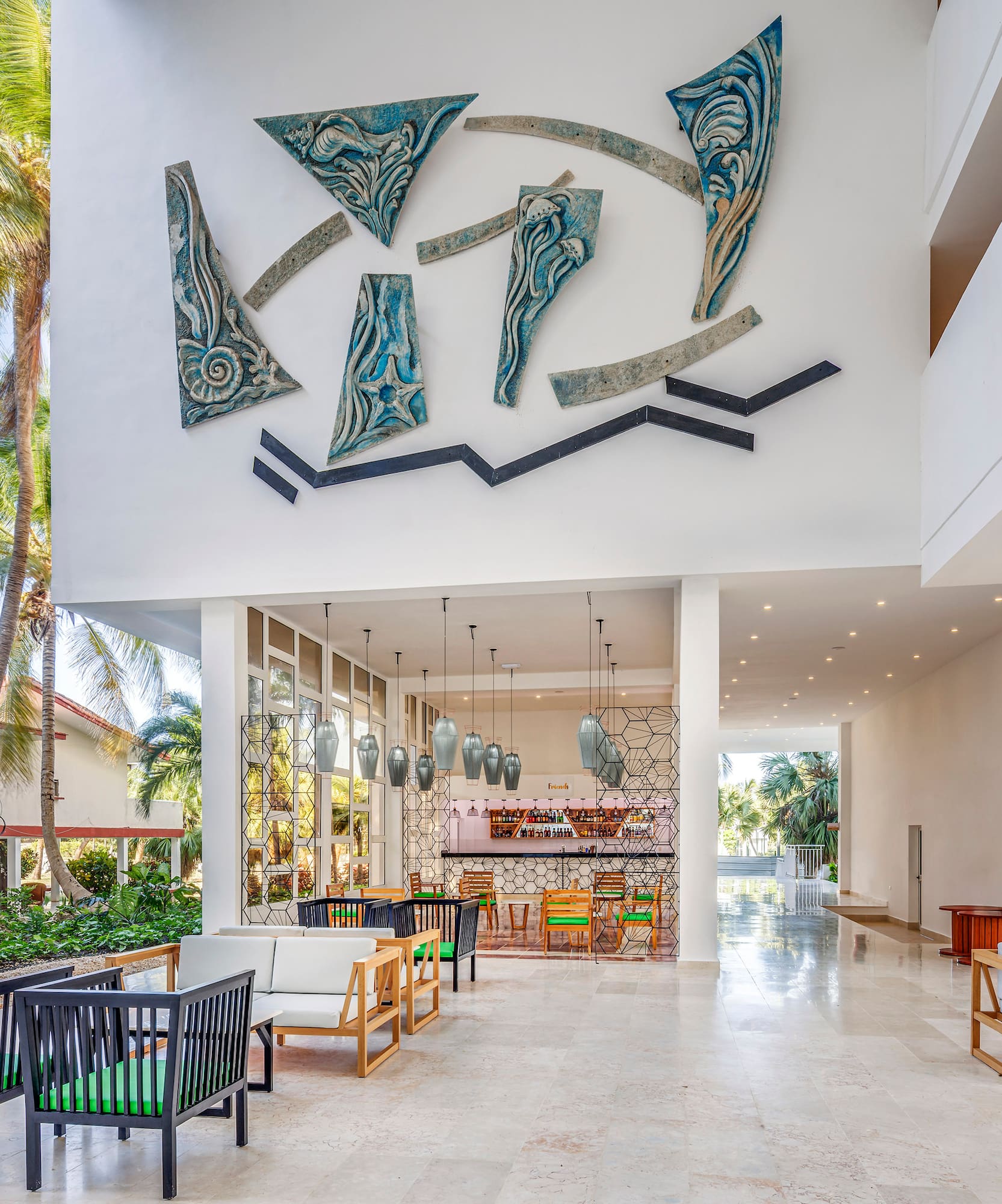 a large white building with a white wall and chairs
