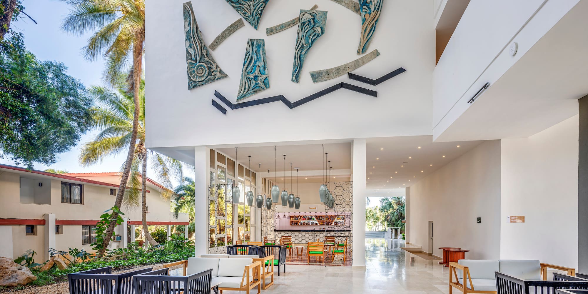 a large white building with a white wall and chairs