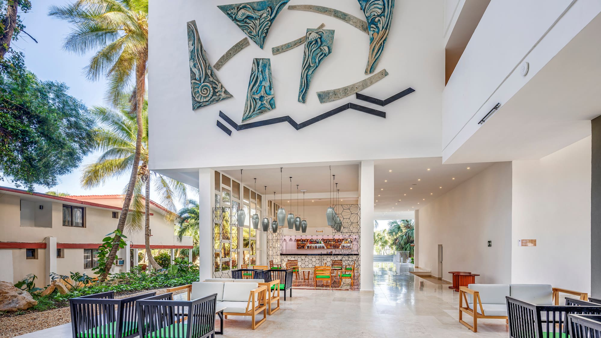 a large white building with a white wall and chairs