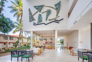 a large white building with a white wall and chairs