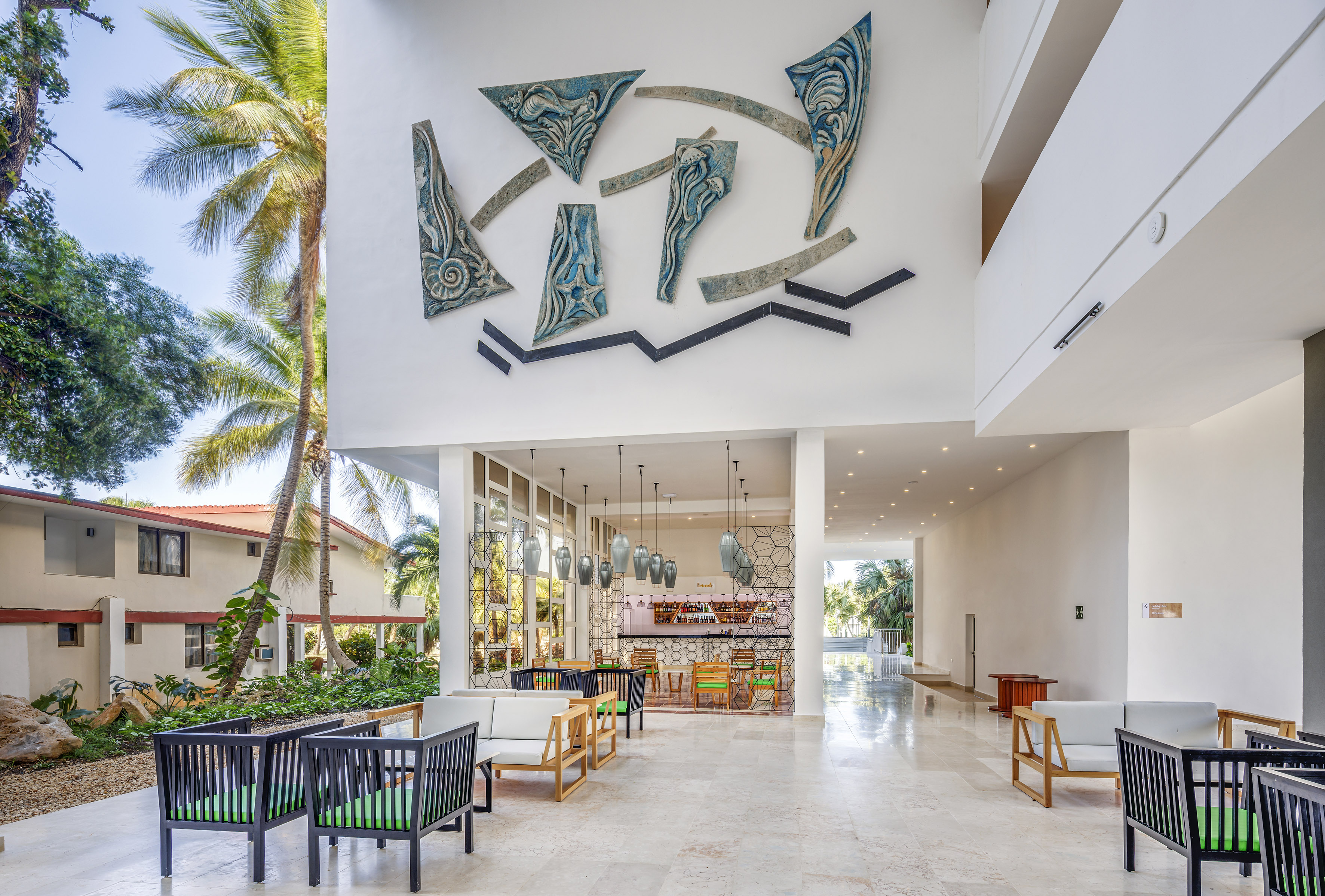 a large white building with a white wall and chairs