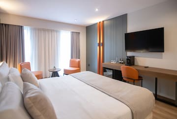 a room with a bed and a television