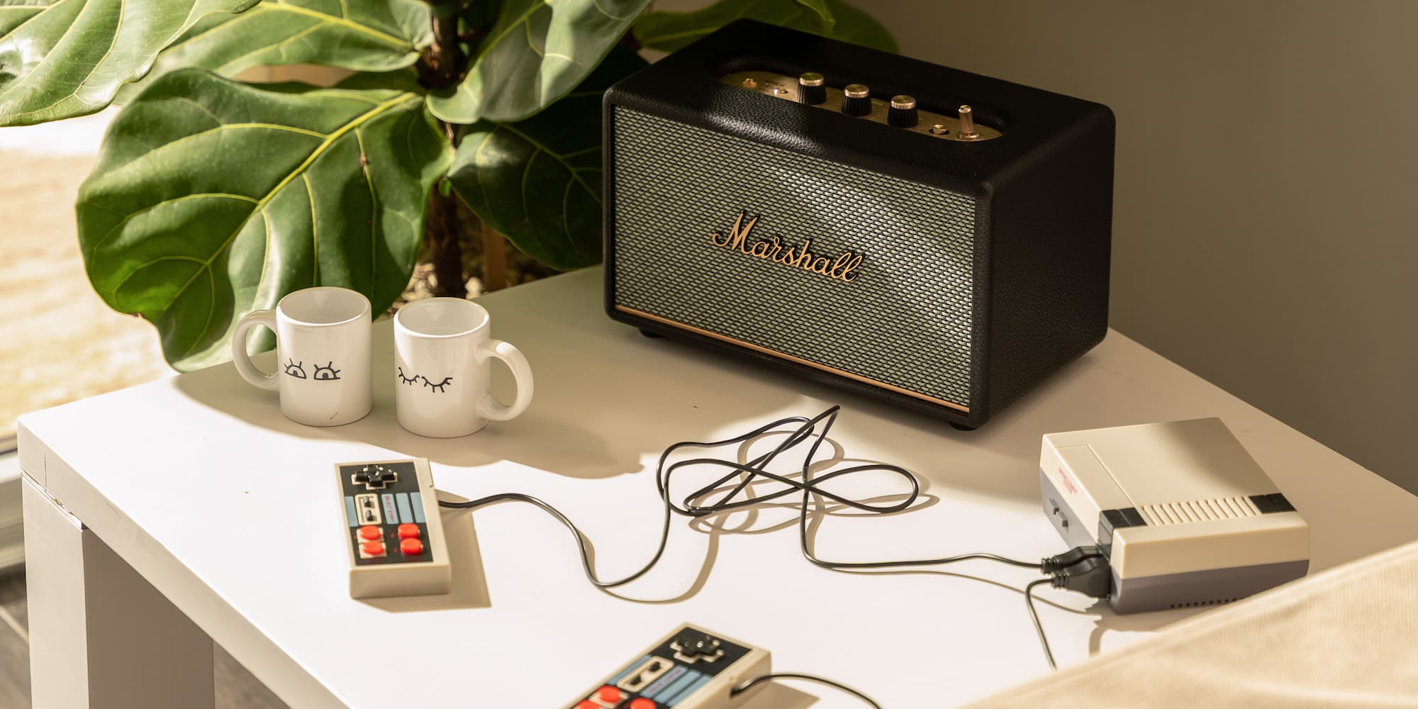 a coffee table with a speaker and two coffee cups