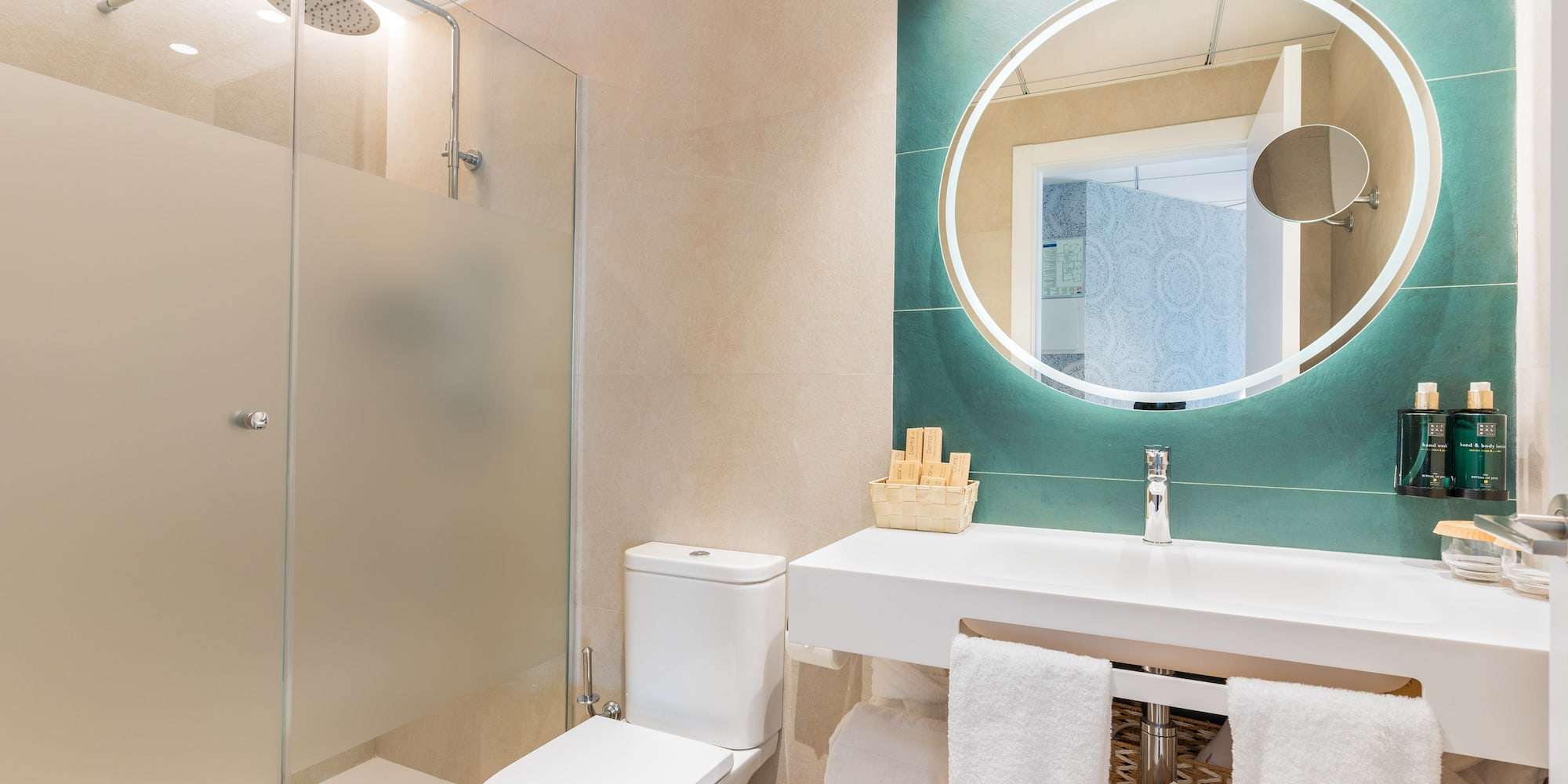 a bathroom with a round mirror and a sink