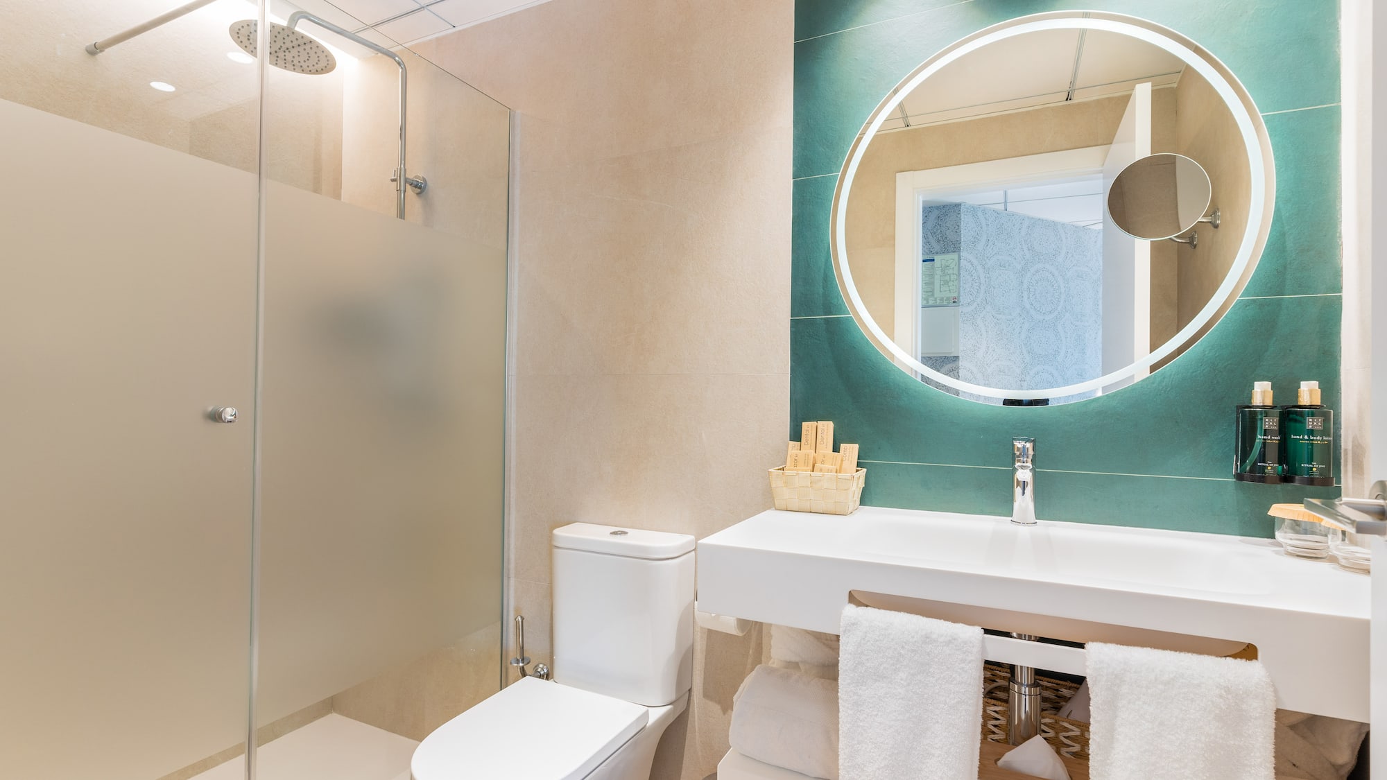 a bathroom with a round mirror and a sink