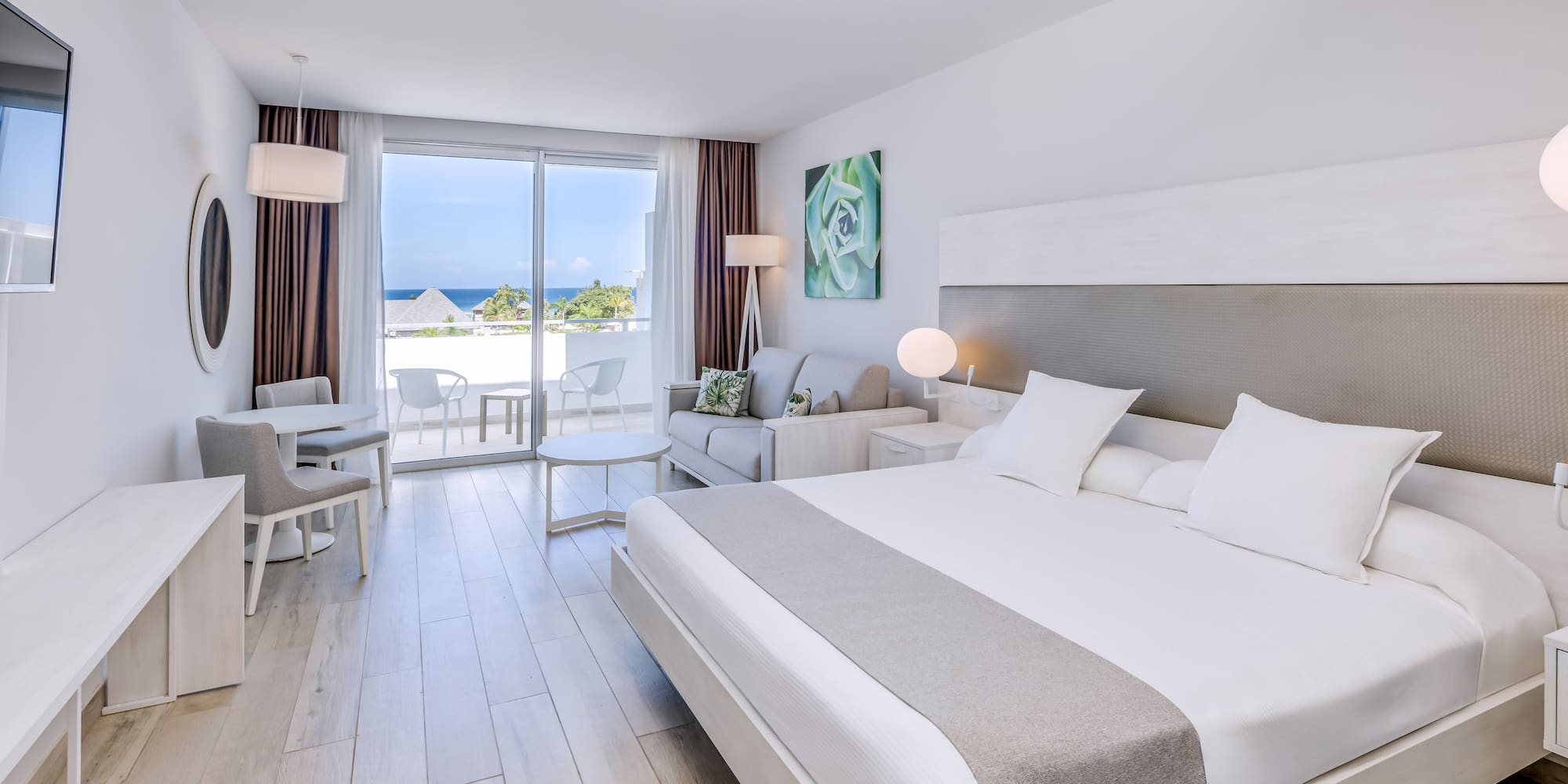 a bedroom with a large bed and a table and chairs