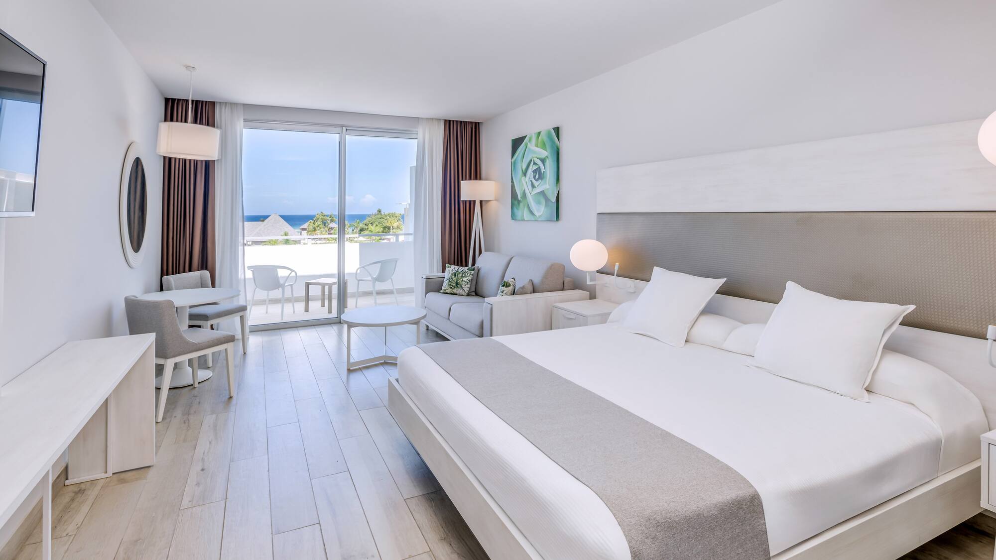 a bedroom with a large bed and a table and chairs