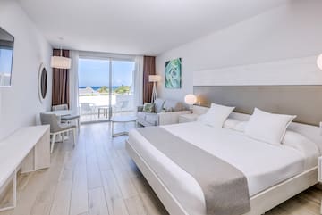 a bedroom with a large bed and a table and chairs