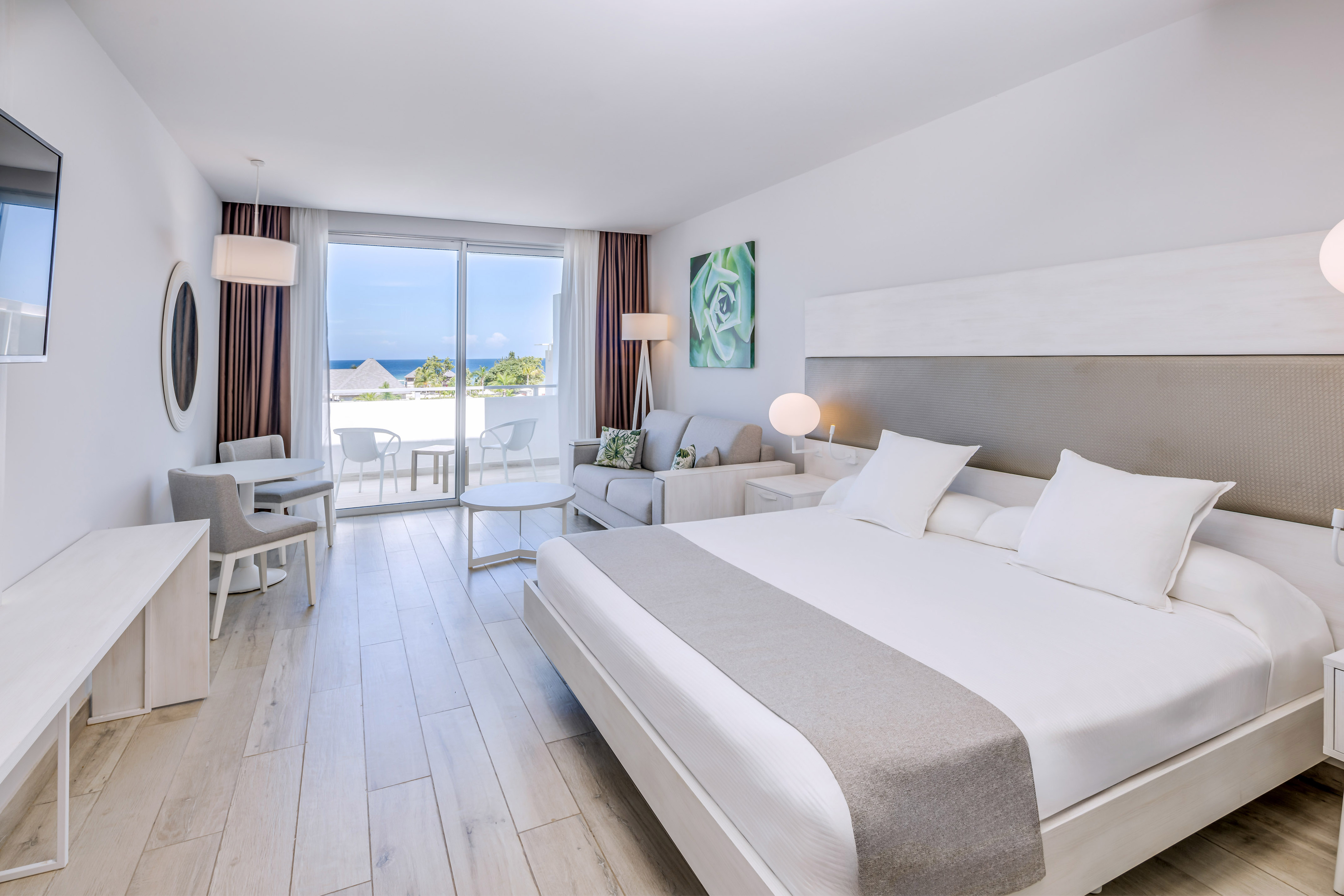 a bedroom with a large bed and a table and chairs