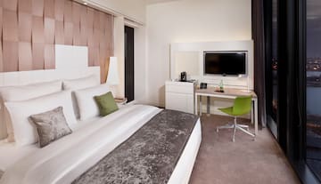 a room with a bed and a desk and a television