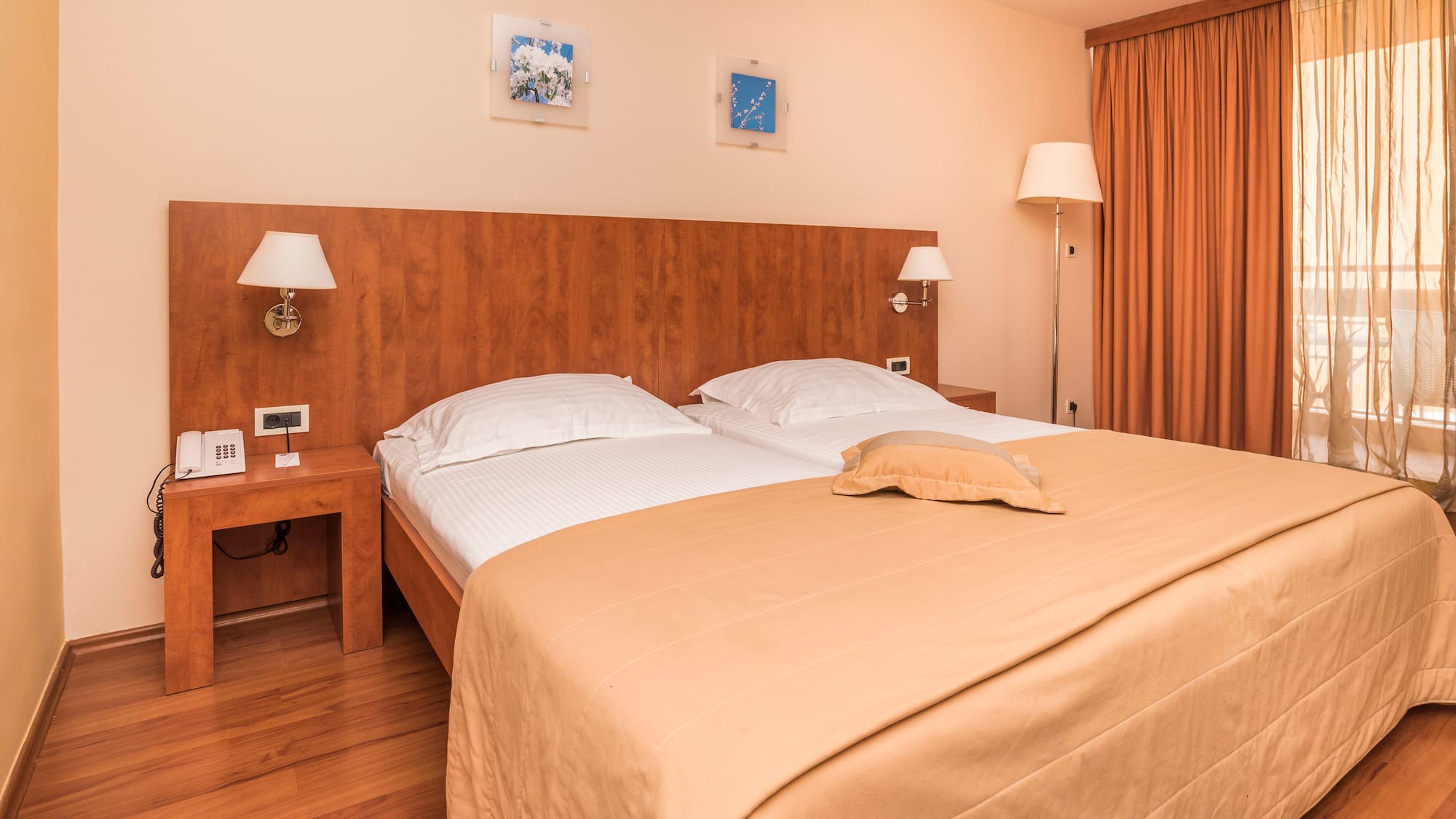a bed with two lamps and a wood headboard