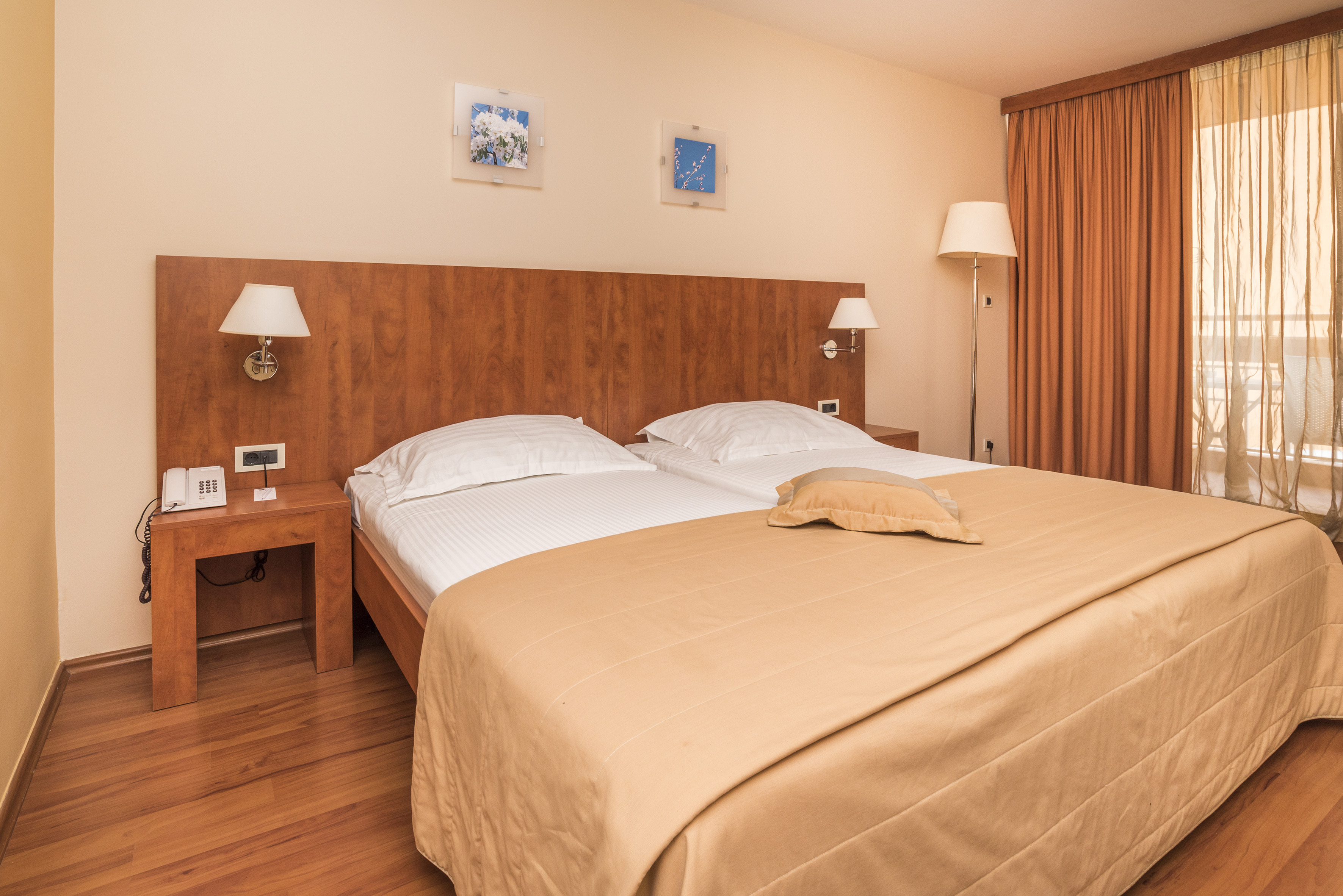 a bed with two lamps and a wood headboard