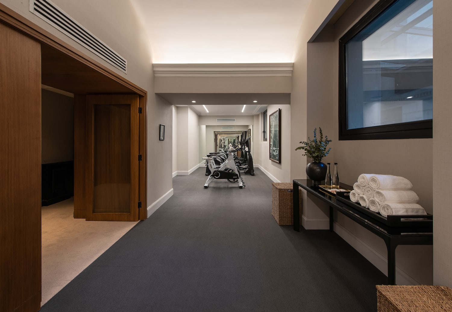 a hallway with exercise equipment and a mirror