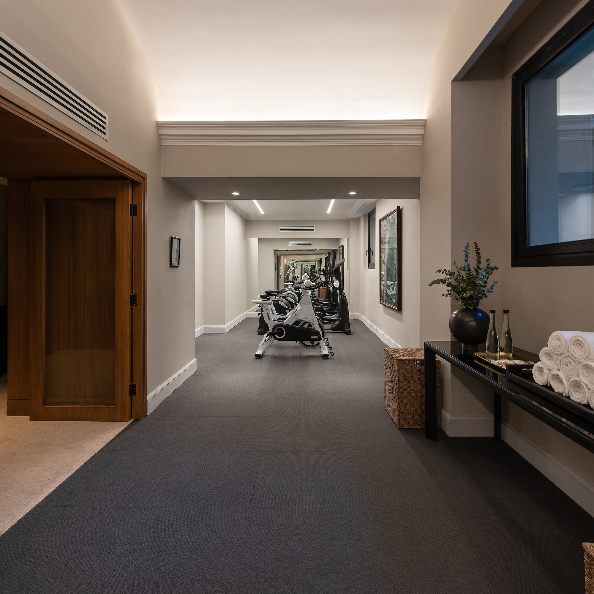 a hallway with exercise equipment and a mirror