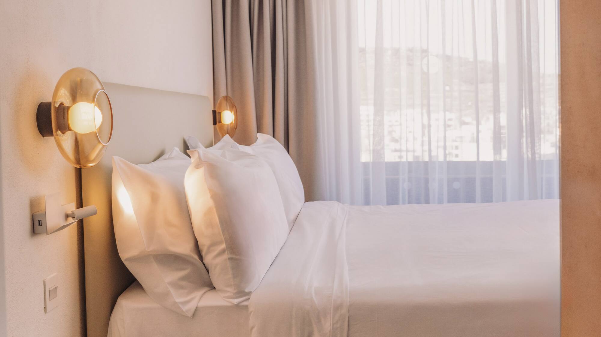 a bed with white sheets and a yellow end table