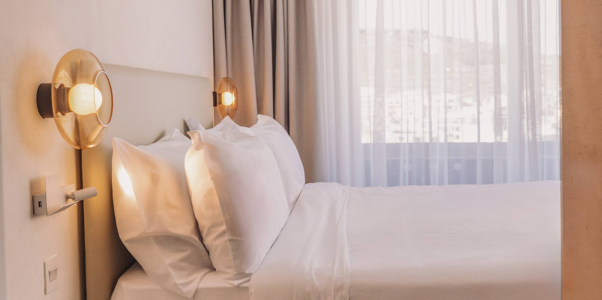 a bed with white sheets and a yellow end table