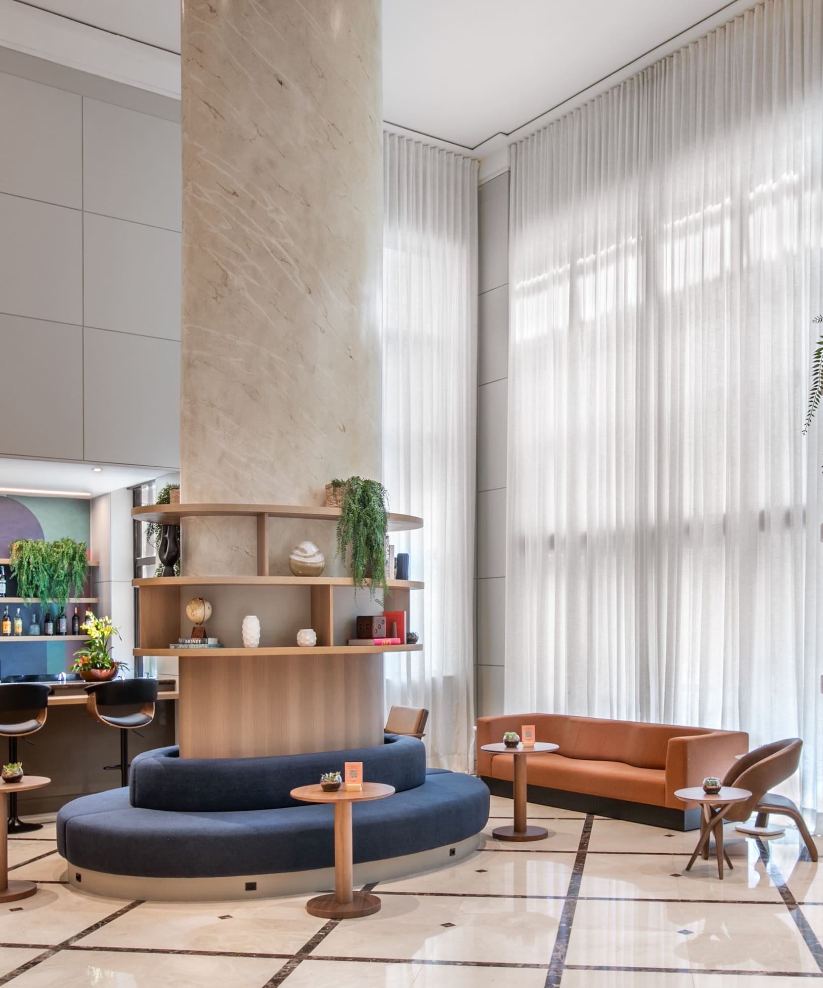 a room with a large column and a round table and chairs