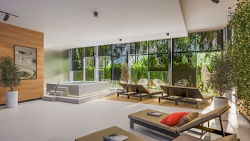 a room with a hot tub and chairs