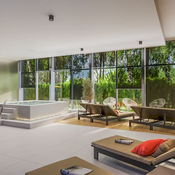 a room with a hot tub and chairs