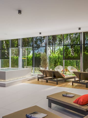 a room with a hot tub and chairs